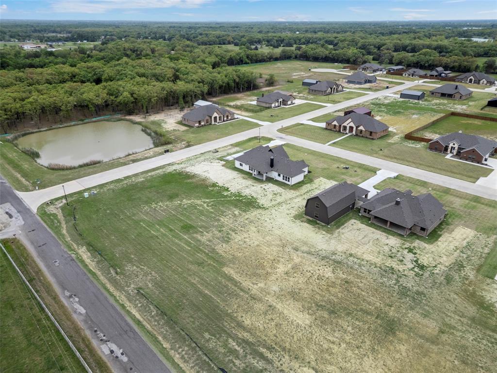 Newly constructed residential development featuring a private pond and surrounding wooded areas