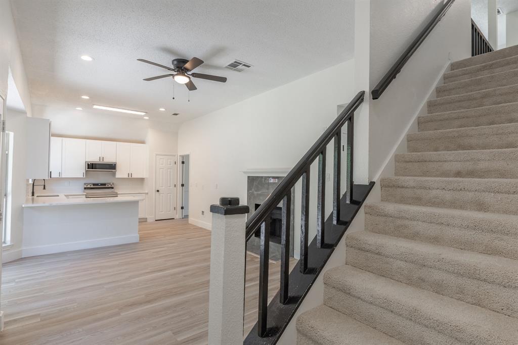 Carpeted staircase with black railing