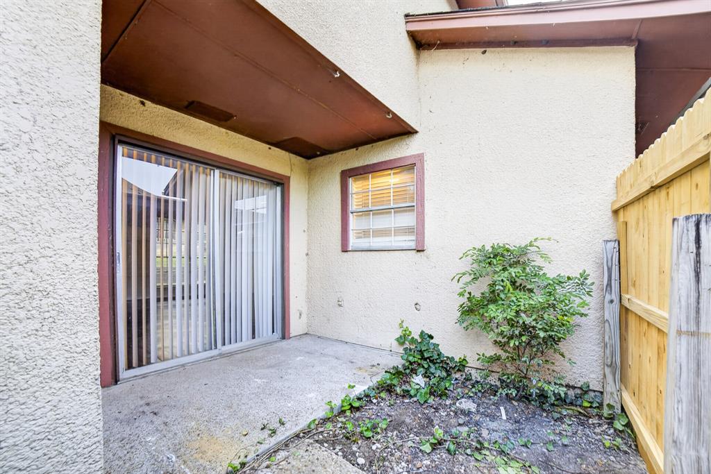 Fenced courtyard with storage and patio doors