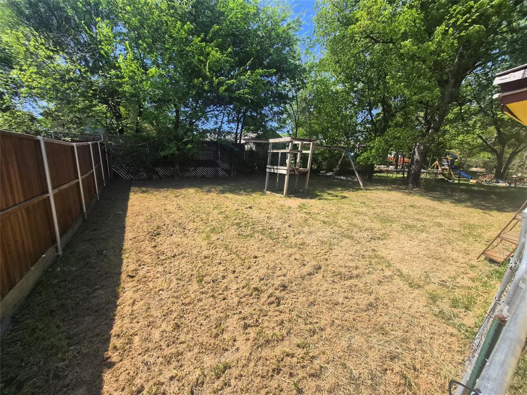 Spacious backyard featuring wood fencing and mature trees