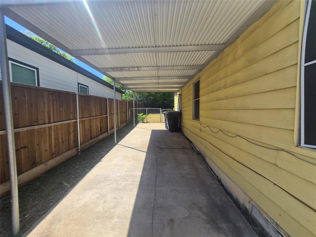 Covered concrete walkway extending alongside the property