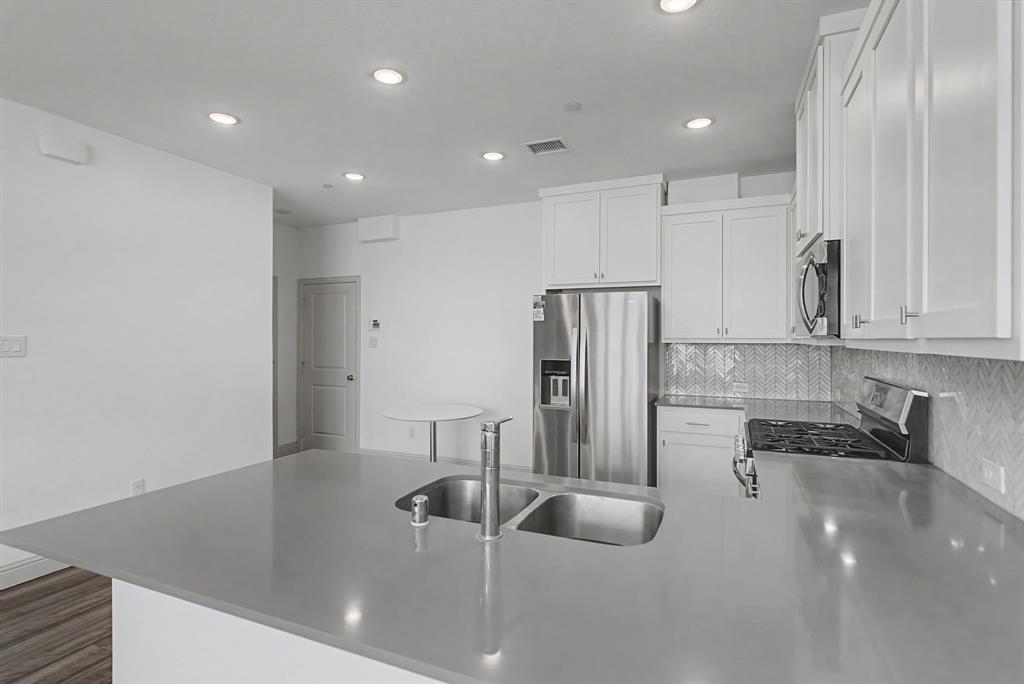 Kitchen island featuring a double basin stainless steel sink and gooseneck faucet