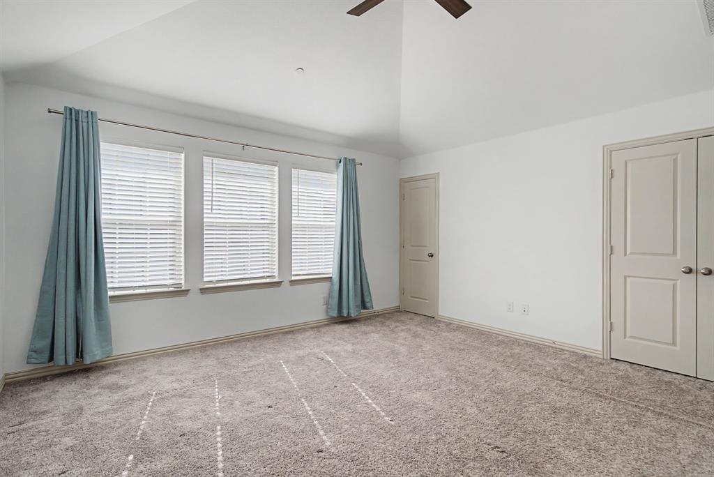 Vaulted ceiling room with ceiling fan and carpet flooring