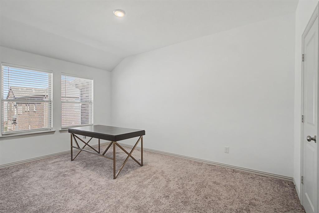 Room with neutral carpet flooring, white walls, and a vaulted ceiling