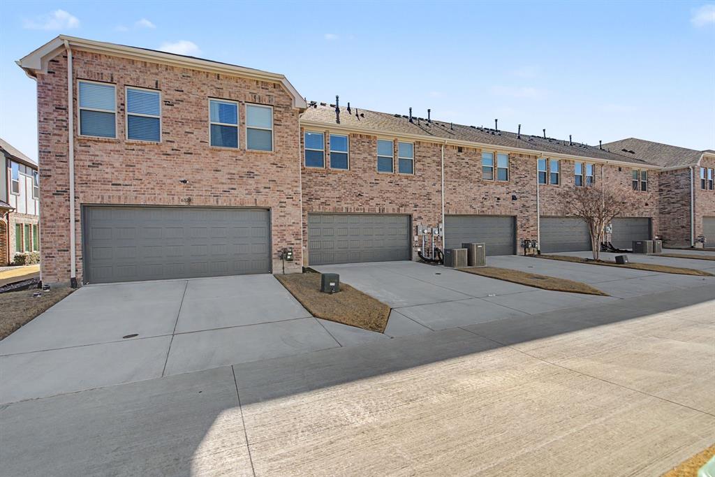 Townhome-style residences featuring brick exteriors, multiple window configurations, and individual garages