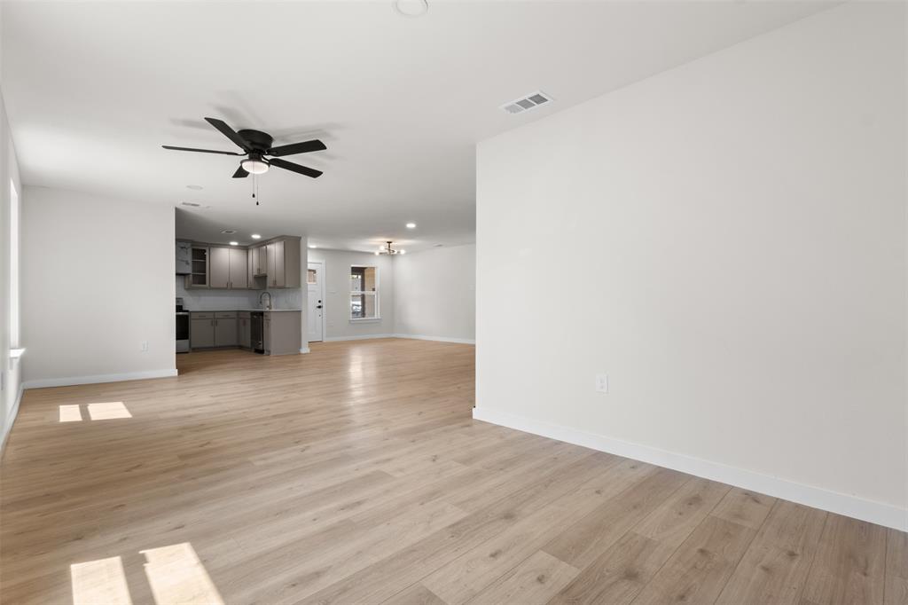 Expansive room with light wood-finish flooring, recessed lighting, and a ceiling fan