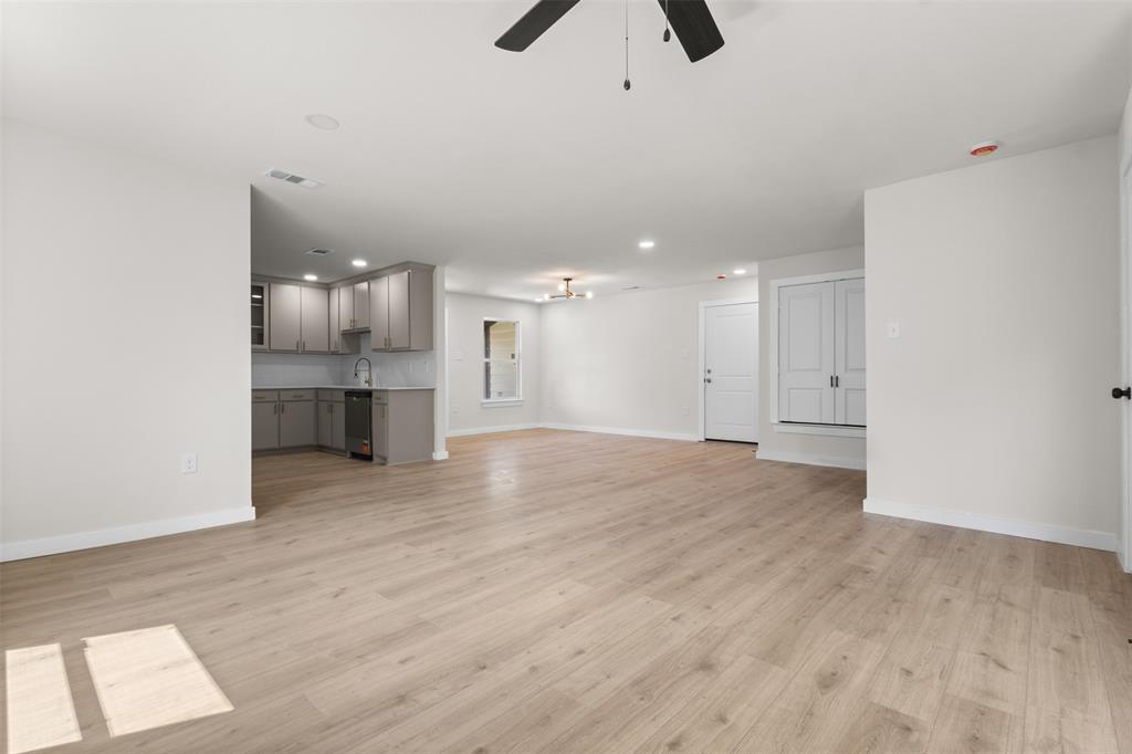 Open-concept living space with wood-finish flooring, recessed lighting, and a ceiling fan