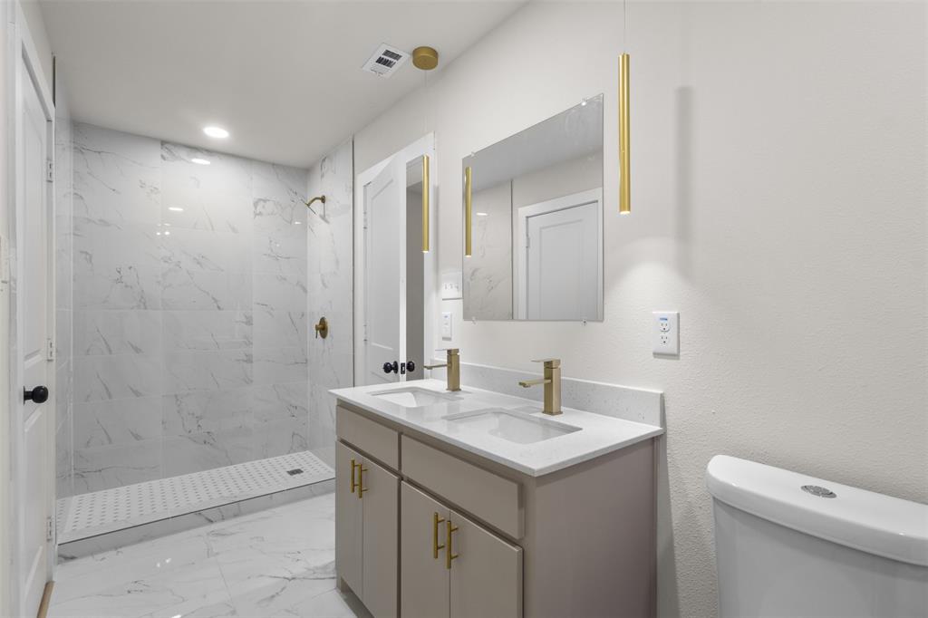 Dual vanity with quartz countertop, undermount sinks, and gold-finish fixtures