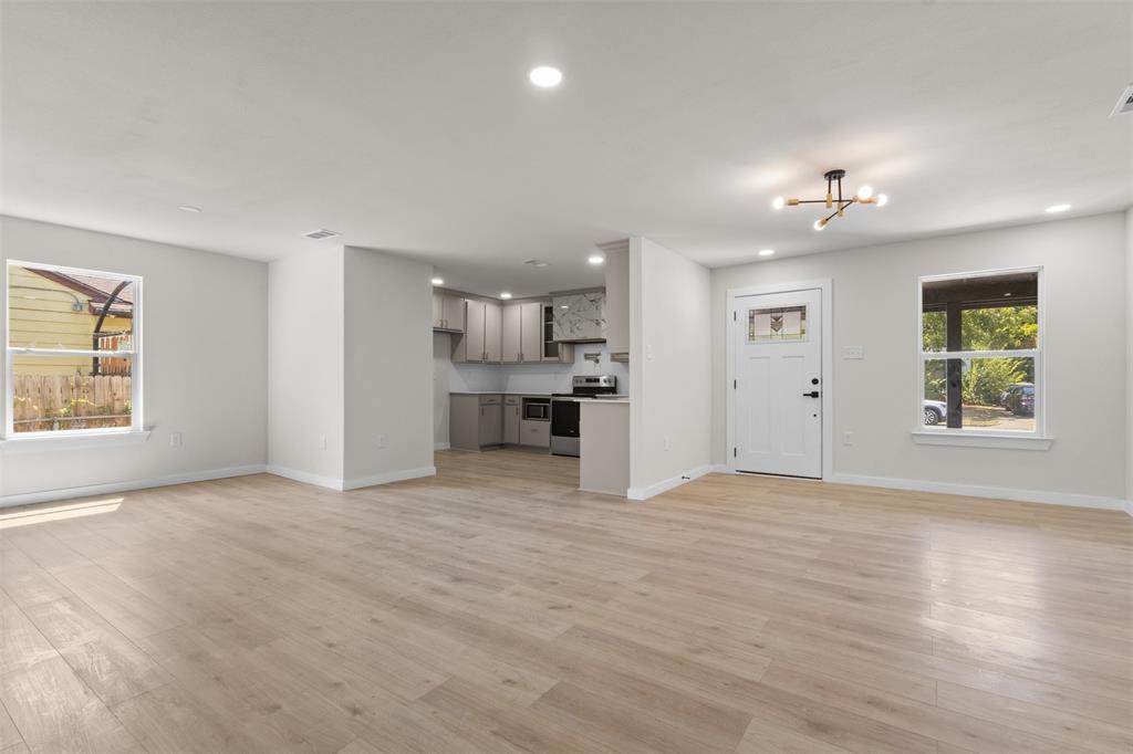 Open-concept living space with light wood-finish flooring, recessed lighting, and a modern ceiling fixture