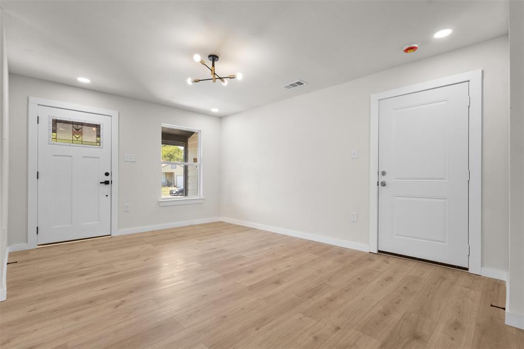 Wood-finish flooring, white walls, recessed lighting, and a modern ceiling fixture