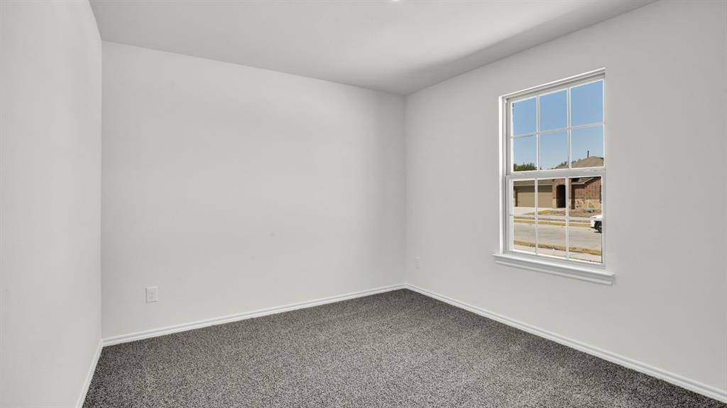 Neutral interior with white walls, gray carpet, and a large window providing ample natural light