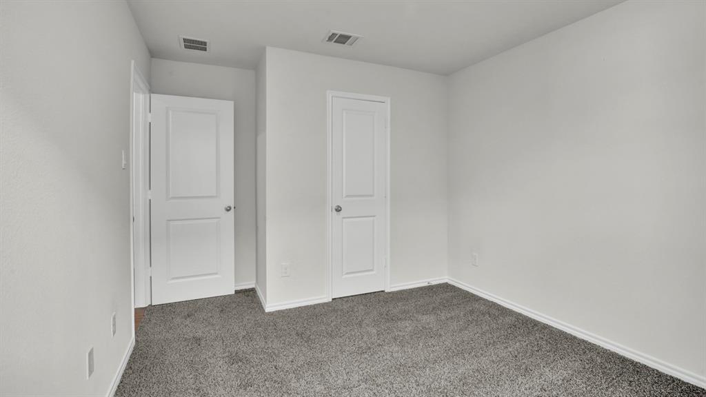 Neutral-toned room featuring a gray carpeted floor, white walls, and white trim