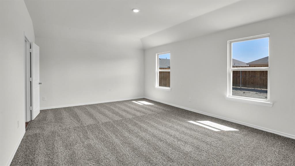 Spacious room featuring neutral carpeting, white walls, two windows, recessed lighting, and a paneled door