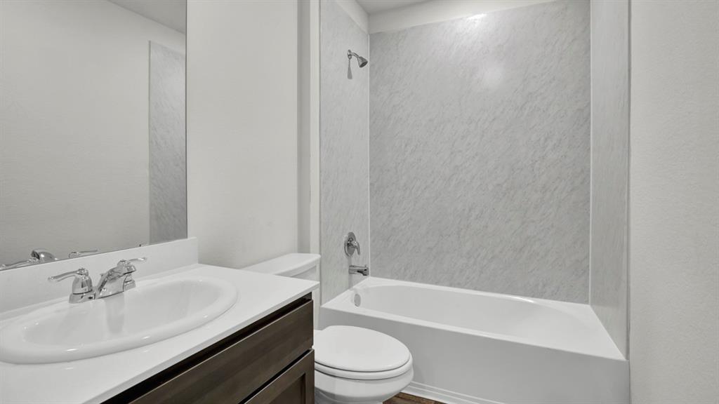 Bathroom featuring a single vanity with a white countertop, an undermount sink, and chrome fixtures