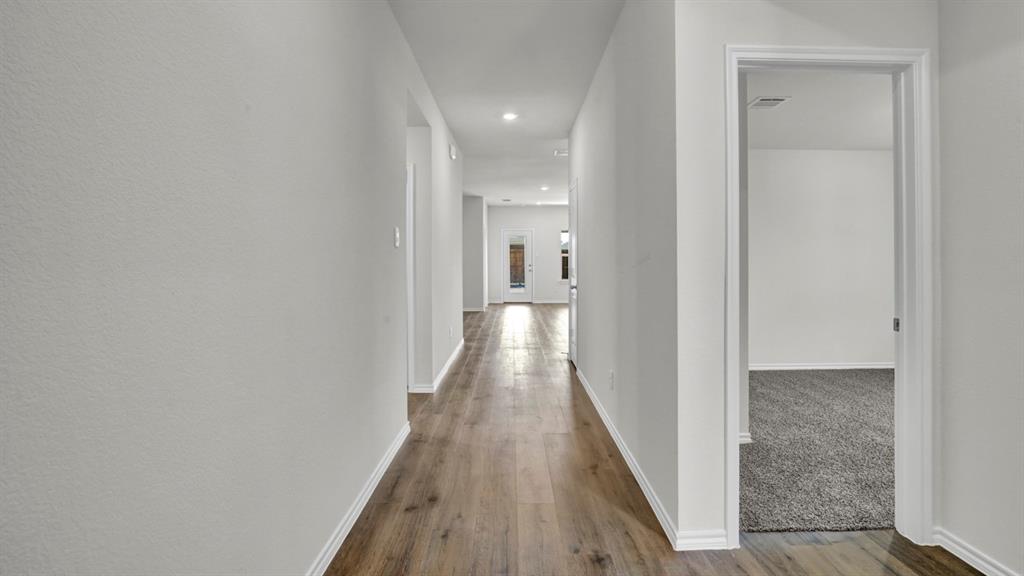 Hallway with wood-finish flooring, recessed lighting, and crisp white trim