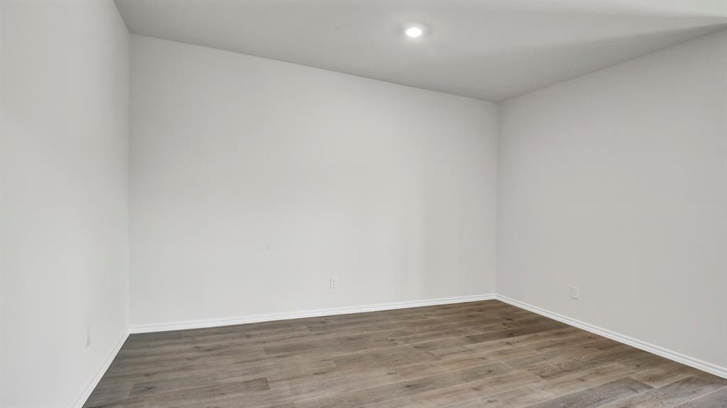 Interior room featuring light-toned walls, wood-finish flooring, recessed lighting, and white baseboards