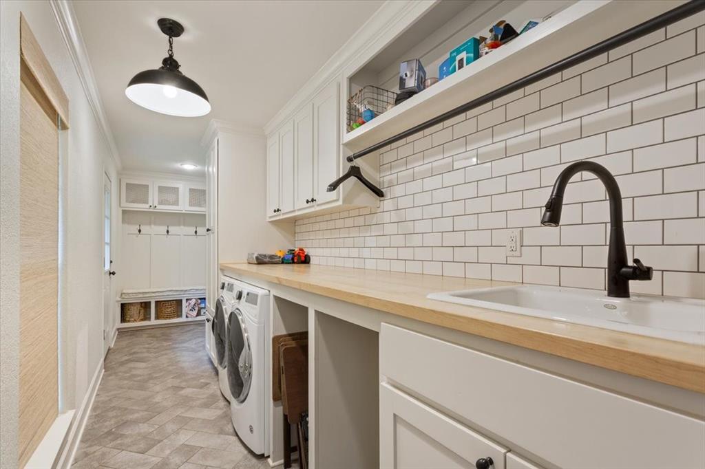 Utility room featuring white shaker cabinetry, an undermount sink with a matte black faucet, wood-finish countertops, and a white subway tile backsplash