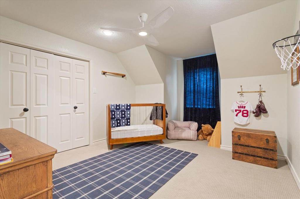 Upstairs carpeted room featuring a ceiling fan with integrated lighting, a double bi-fold closet, and a window with dark curtains