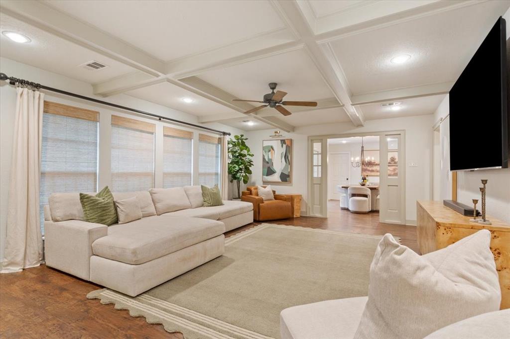 Living area with coffered ceilings, wood-finish flooring, and recessed lighting Living area with coffered ceilings, wood-finish flooring, and recessed lighting