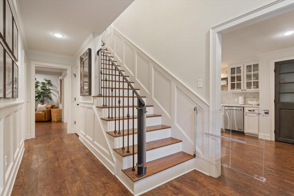 Staircase featuring wood treads, white risers, and wrought iron balusters with a dark handrail Staircase featuring wood treads, white risers, and wrought iron balusters with a dark handrail
