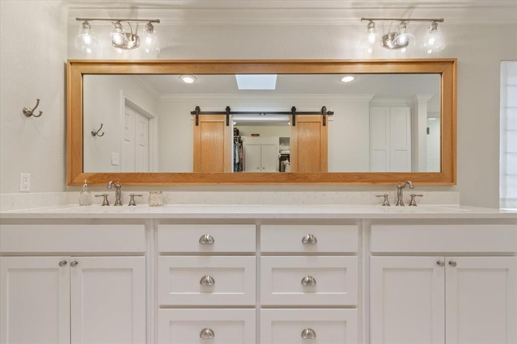 Upstairs dual vanity with white cabinetry, light-toned countertops, and brushed nickel hardware
