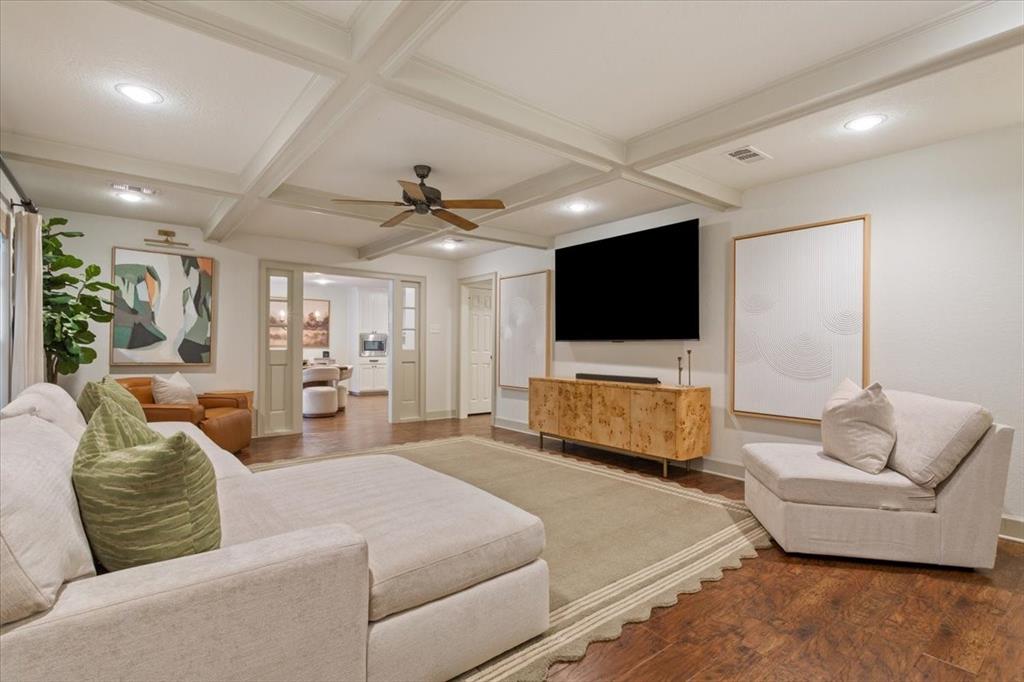 Spacious room featuring coffered ceilings, recessed lighting, and wood-finish flooring Spacious room featuring coffered ceilings, recessed lighting, and wood-finish flooring