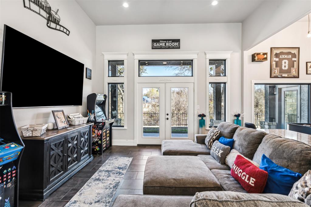 Spacious room featuring high ceilings, dark wood-finish flooring, recessed lighting, and white trim