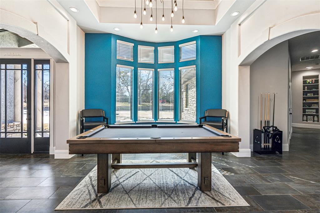 Game room featuring a dark wood-finish pool table centered on a light area rug
