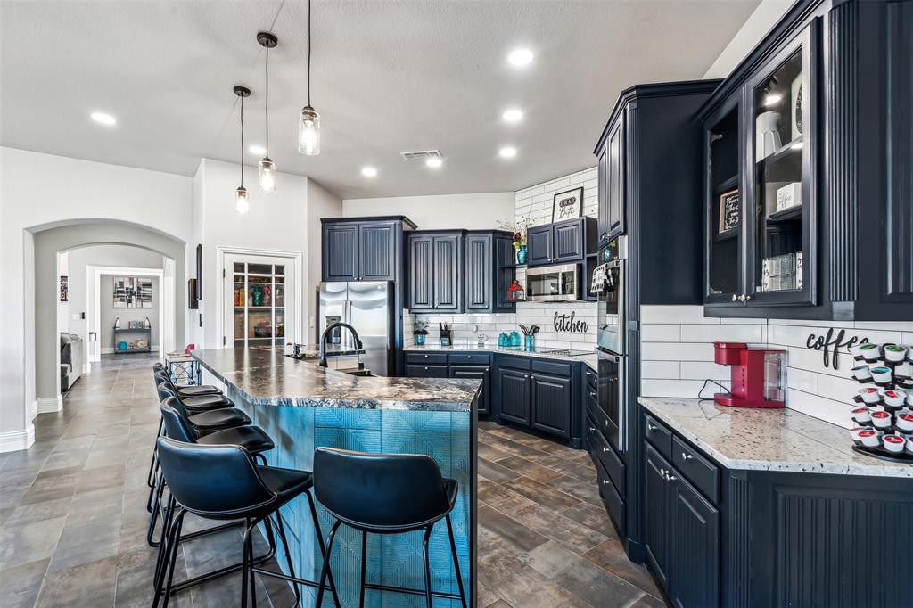 Contemporary kitchen featuring dark wood cabinetry and a large island with a substantial countertop