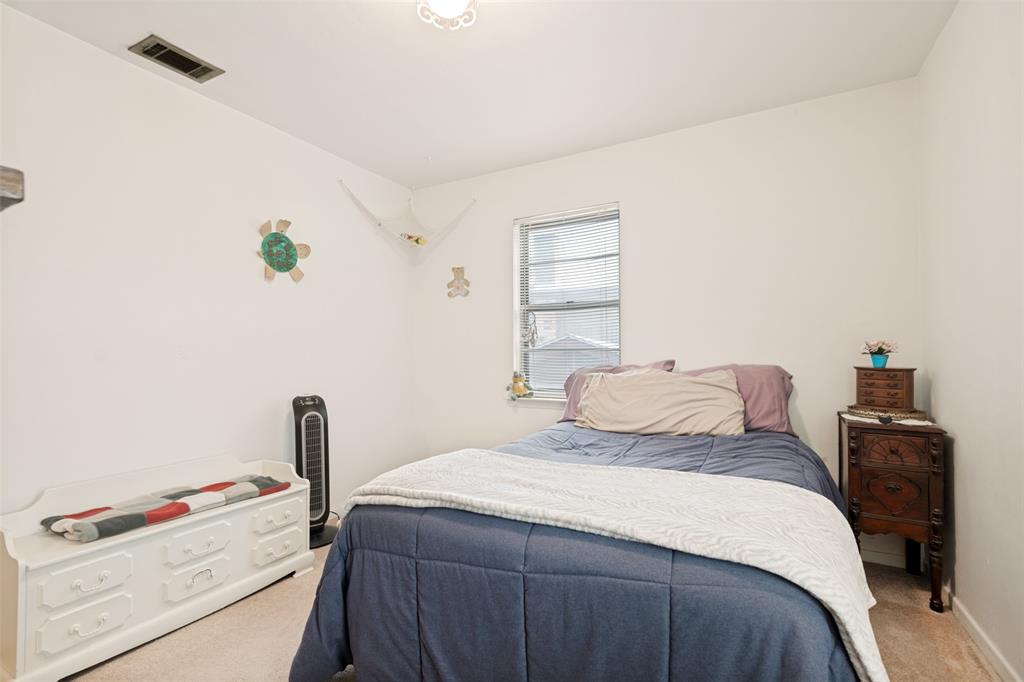 Carpeted room featuring a window with blinds, white walls, and a ceiling light fixture