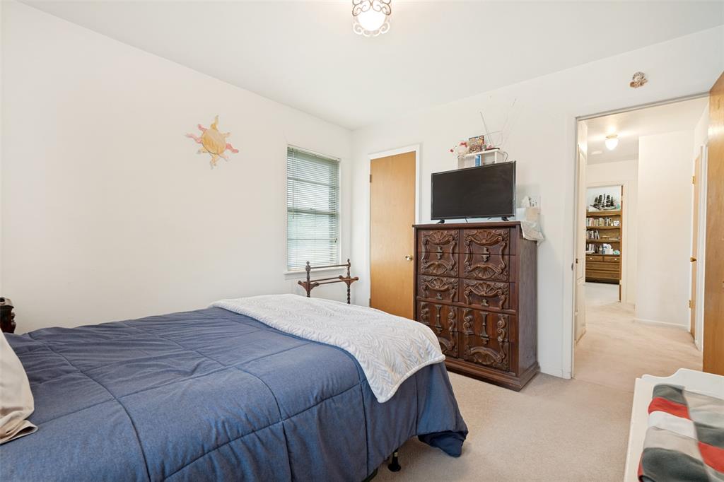Bedroom featuring neutral wall paint, carpet flooring, a window with horizontal blinds, and a ceiling-mounted light fixture