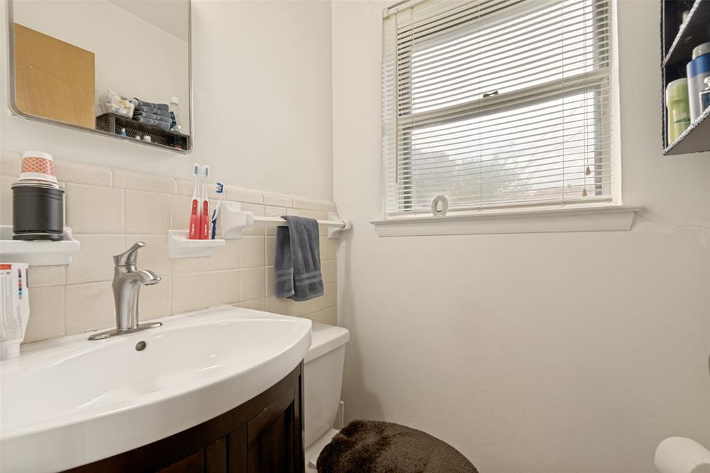 White vanity with integrated sink, brushed nickel faucet, and tiled backsplash