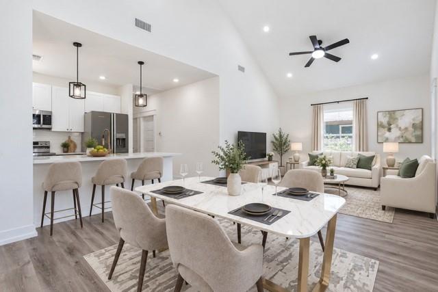 Virtual staging - Open-concept living space featuring wood-finish flooring, a vaulted ceiling, and recessed lighting Virtual staging - Open-concept living space featuring wood-finish flooring, a vaulted ceiling, and recessed lighting