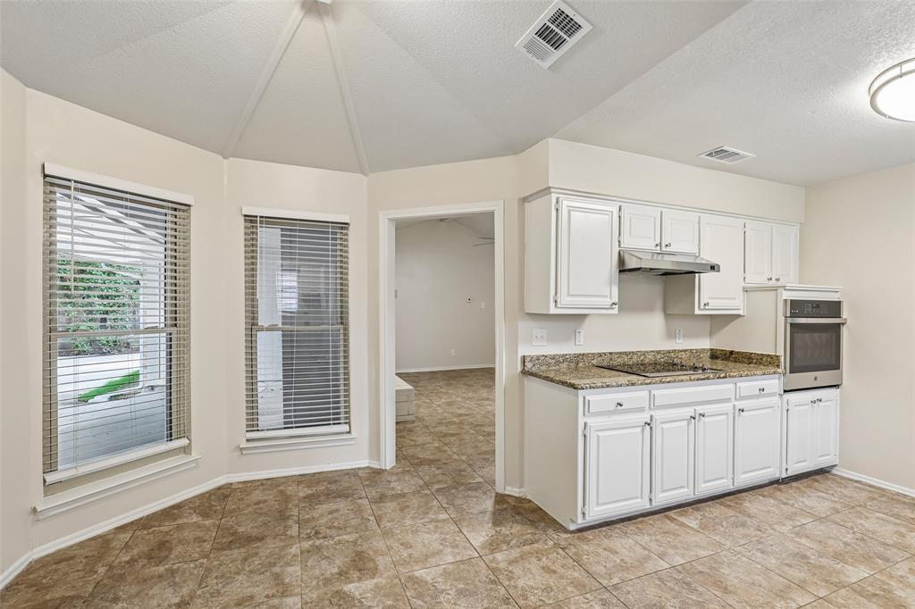 Kitchen featuring white cabinetry, a built-in oven, a stovetop, and granite-style countertops