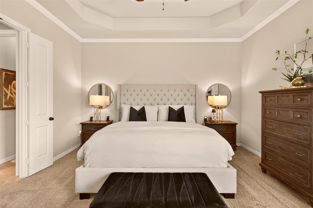 Spacious primary bedroom features a tray ceiling and room for a comfortable sitting area.