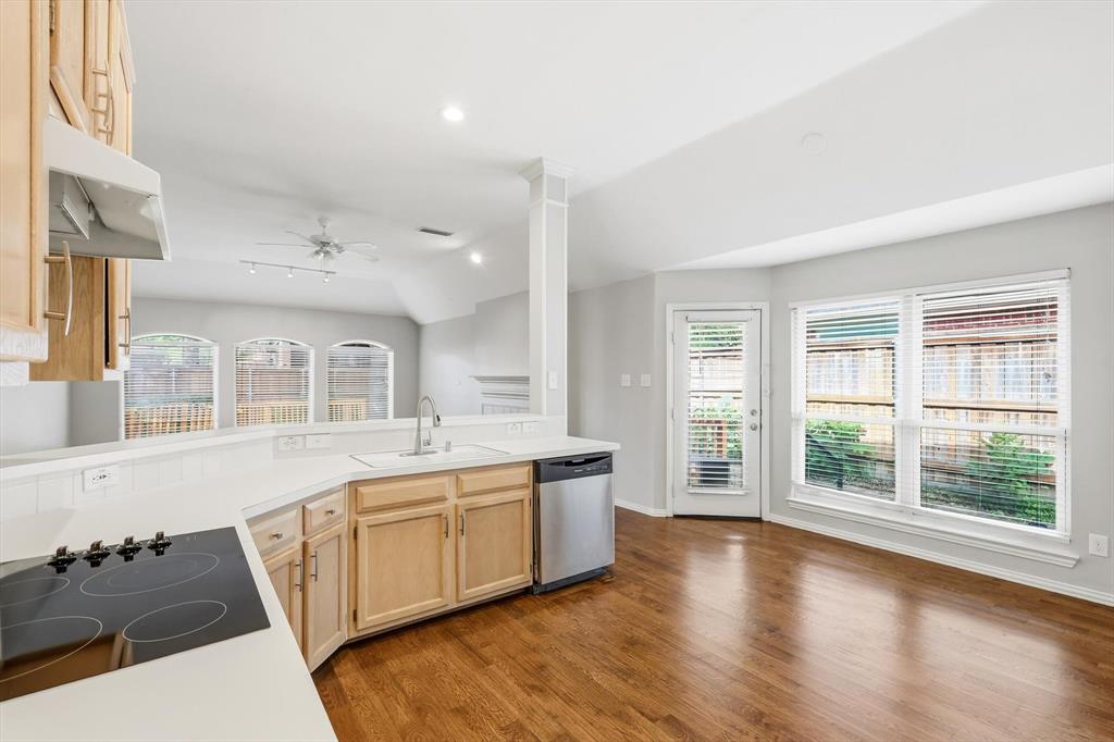 Kitchen featuring a built-in cooktop, stainless steel dishwasher, and light wood cabinetry