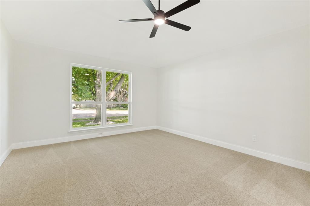 Neutral paint palette with carpet flooring, a large window, a ceiling fan, and white baseboards