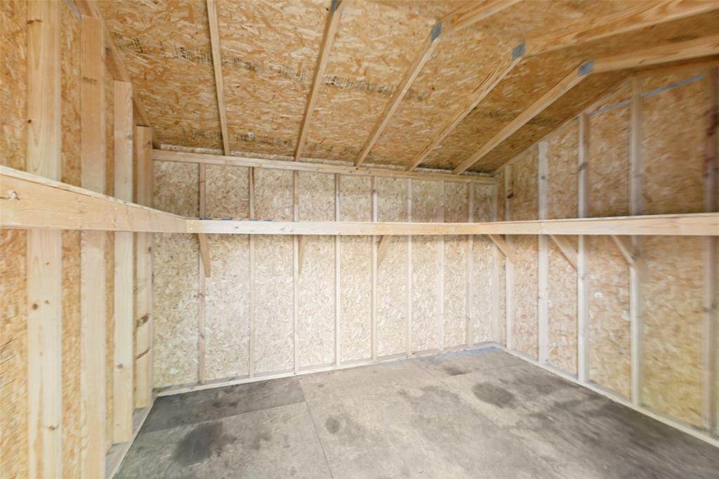 Interior structure featuring wood framing and OSB paneling, concrete flooring, and built-in wood shelving