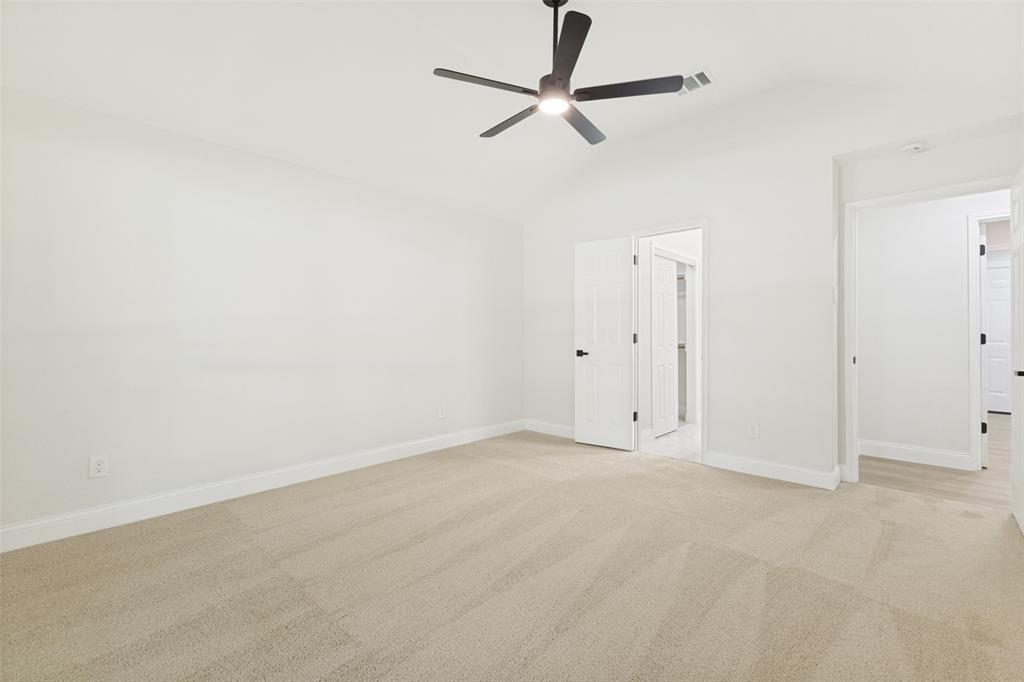 Neutral-toned carpet flooring and white baseboards