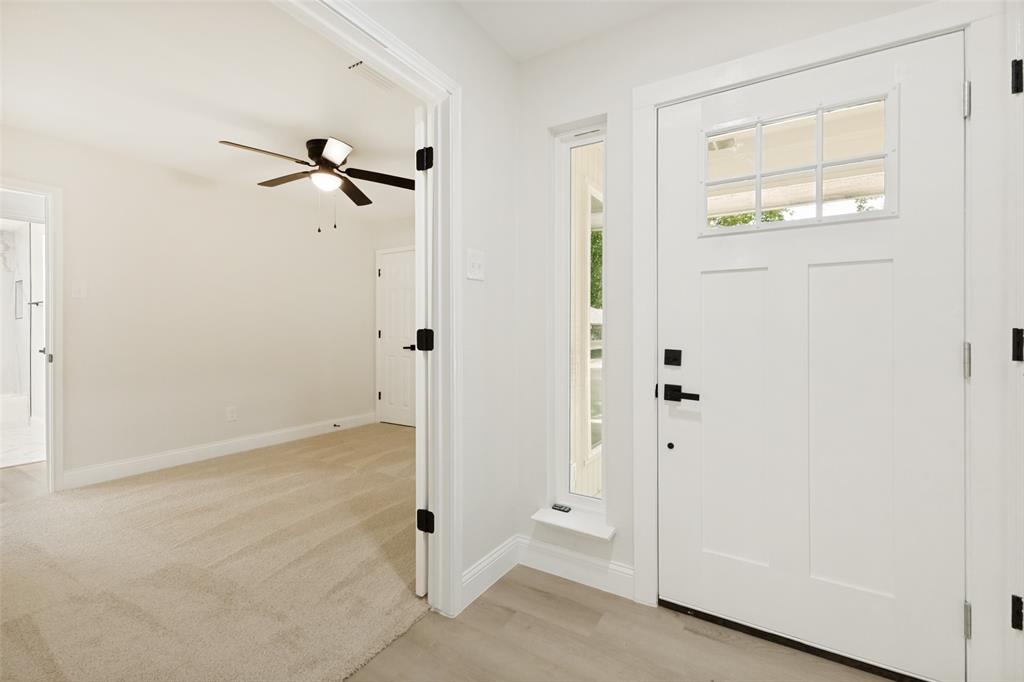 Entryway featuring a white craftsman-style door with a multi-pane window and matte black hardware Entryway featuring a white craftsman-style door with a multi-pane window and matte black hardware