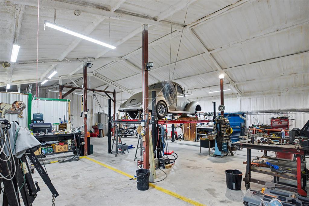 Spacious industrial interior featuring a high vaulted ceiling, exposed structural beams, and concrete flooring