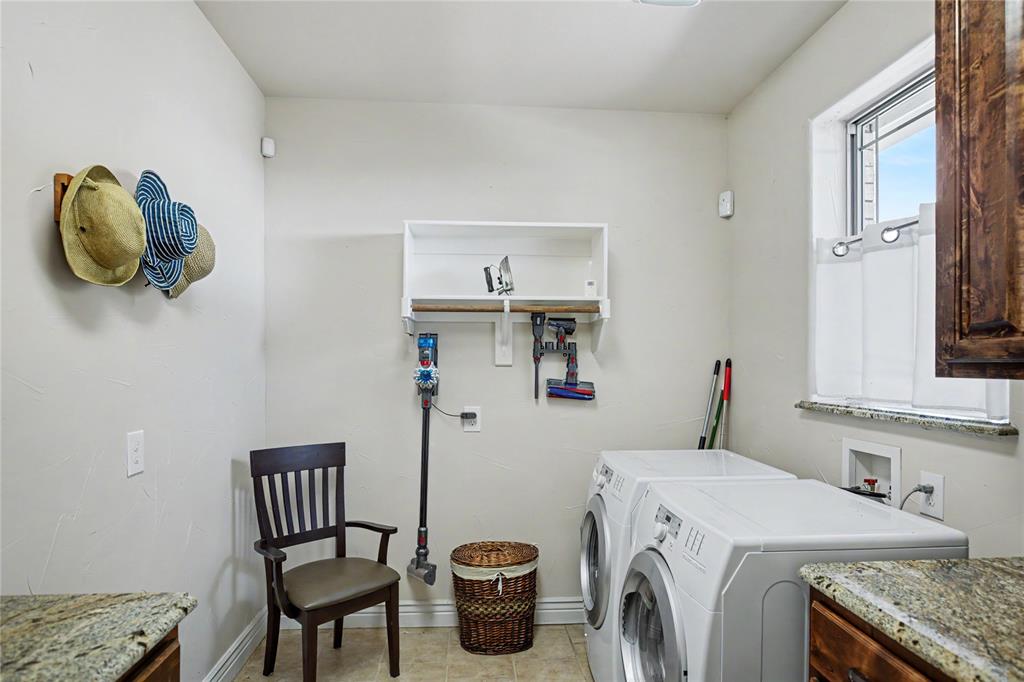 Laundry area featuring light-toned walls, a window with a stone-finish sill, and built-in white shelving