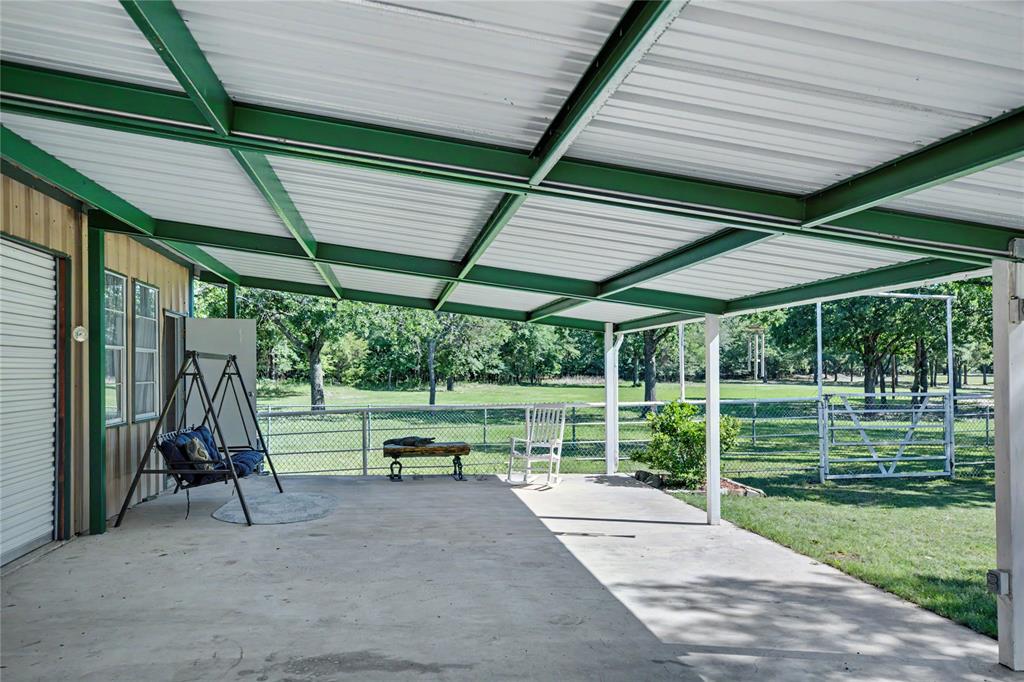 Expansive covered patio featuring a concrete surface and a green metal roof structure