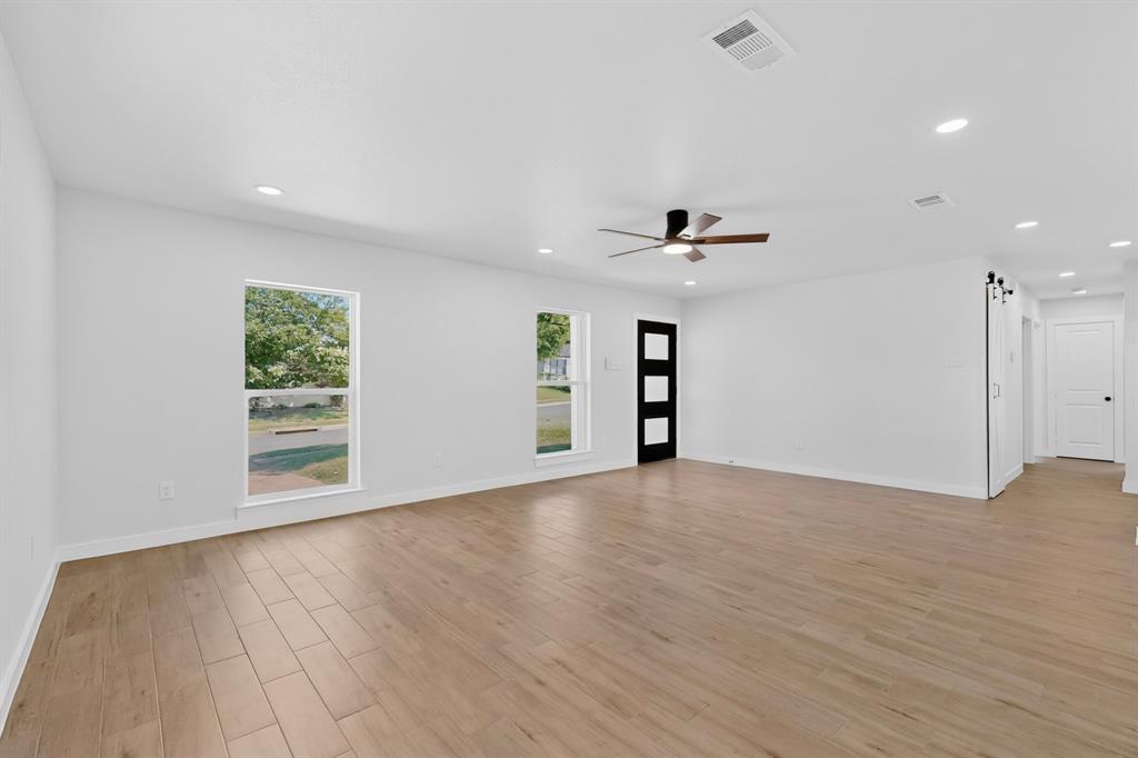 Spacious interior featuring wood-finish flooring, recessed lighting, and a contemporary ceiling fan