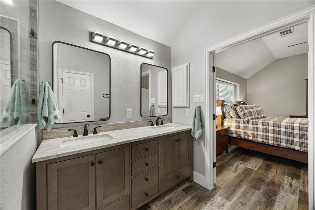 The primary bathroom has been updated with a granite topped vanity with dual sinks, mirrors and lighting.