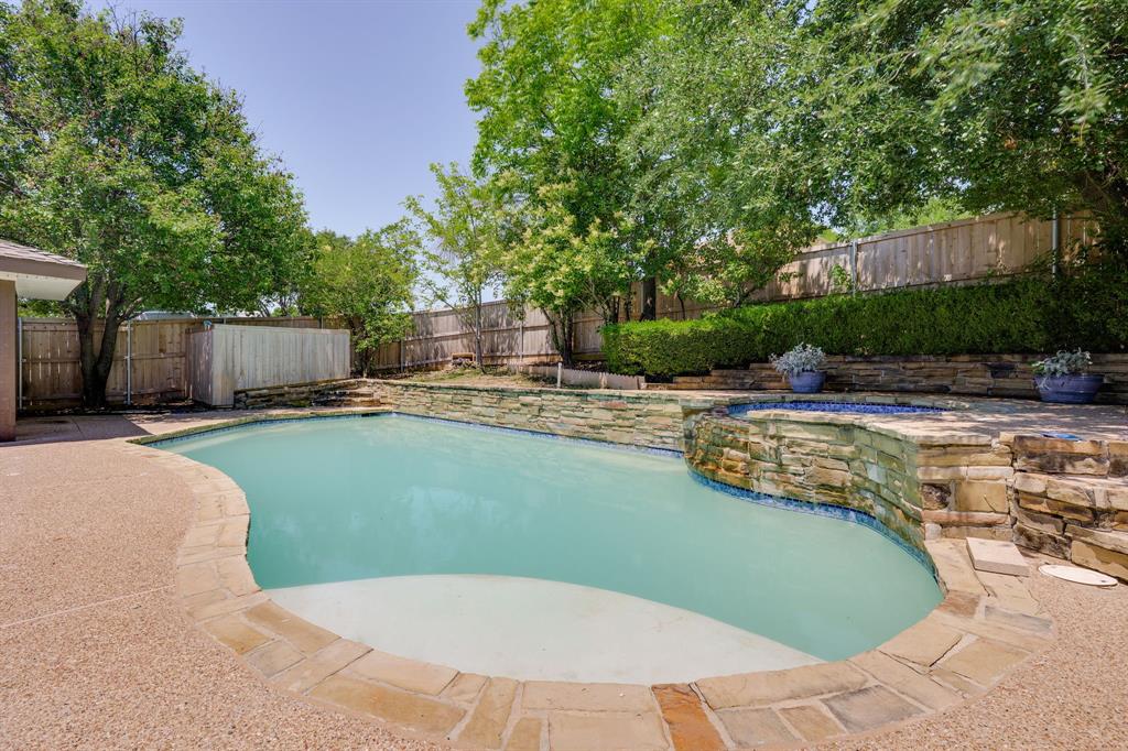 Freeform swimming pool with integrated spa and stone surround