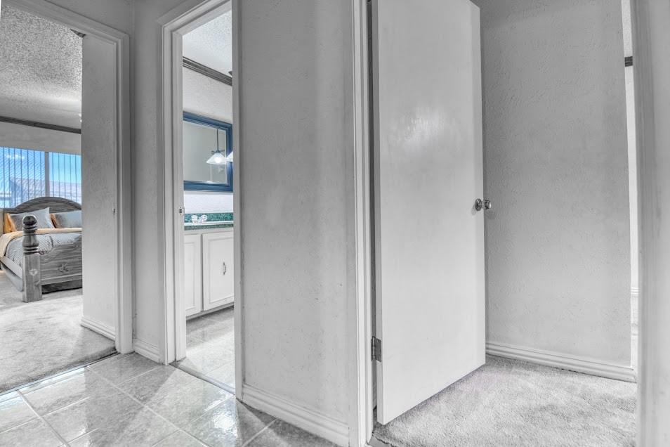 Tile flooring, carpeted room, white painted walls, white doors, white trim