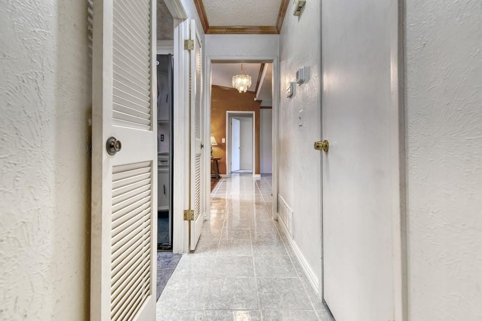 Textured walls, louvered closet doors, and tiled flooring