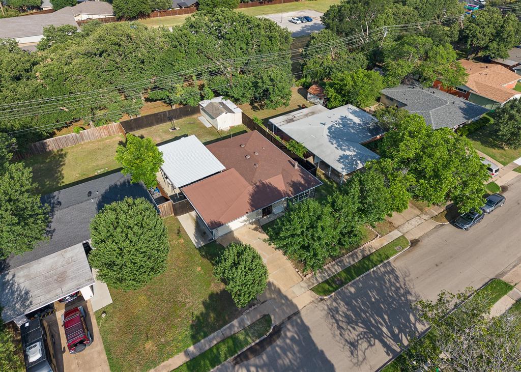 Residential property featuring mature trees, a fenced backyard, and a covered patio area