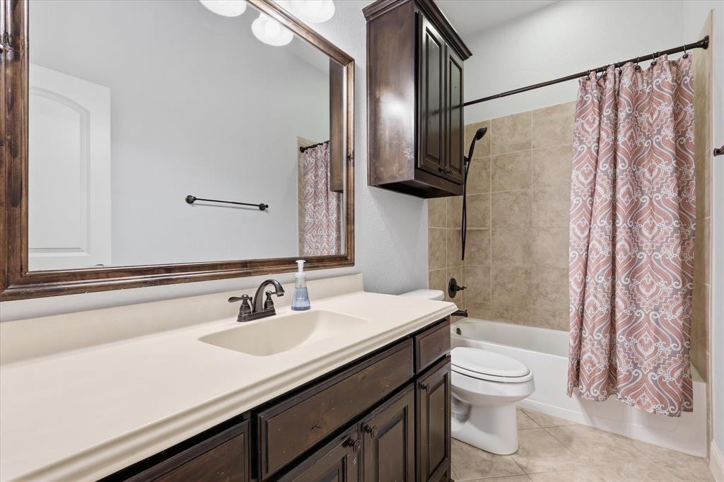 Bathroom featuring a dark wood-finish vanity with an integrated sink and light-colored countertop